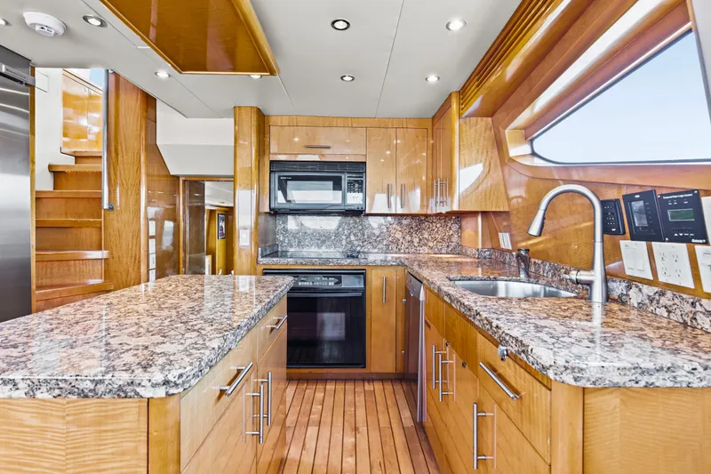 Time-2 Fly Yacht Photos Pics Luxurious kitchen interior of 2006 Hatteras 80 Motor Yacht Sky Lounge with granite countertops.