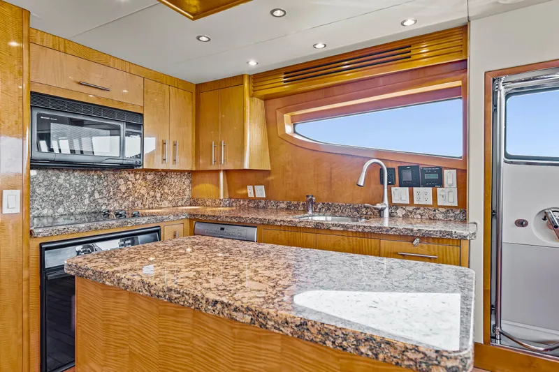 Time-2 Fly Yacht Photos Pics Luxurious kitchen interior of 2006 Hatteras 80 Motor Yacht Sky Lounge with granite countertops.