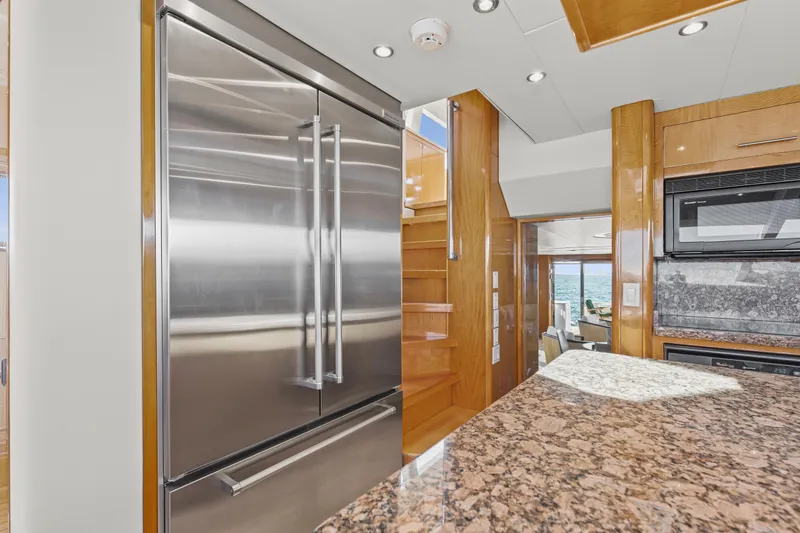 Time-2 Fly Yacht Photos Pics Luxurious kitchen interior of 2006 Hatteras 80 Motor Yacht Sky Lounge with stainless steel appliances.