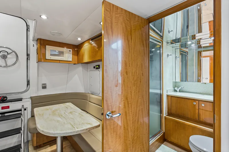 Time-2 Fly Yacht Photos Pics Interior of 2006 Hatteras 80 Motor Yacht Sky Lounge with dining area and bathroom.