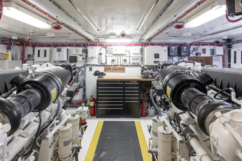 Time-2 Fly Yacht Photos Pics Engine room of 2006 Hatteras 80 Motor Yacht Sky Lounge, featuring dual engines and control panels.