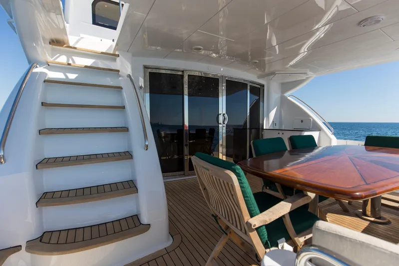 Time-2 Fly Yacht Photos Pics Luxurious 2006 Hatteras 80 Motor Yacht Sky Lounge with elegant outdoor seating and ocean view.