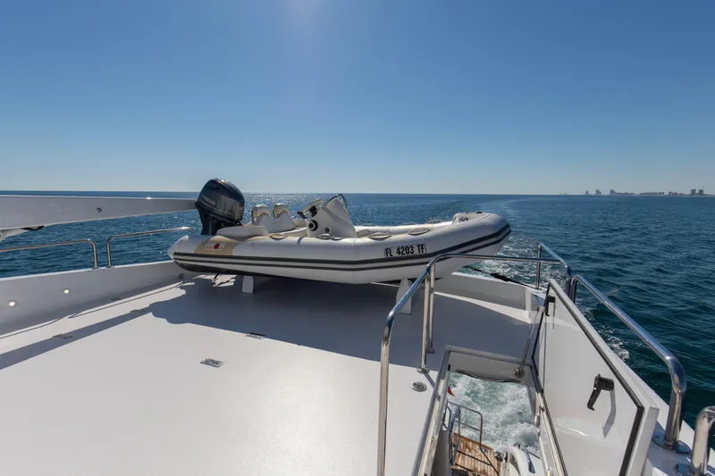 Time-2 Fly Yacht Photos Pics 2006 Hatteras 80 Motor Yacht Sky Lounge with tender on deck, cruising on open sea.