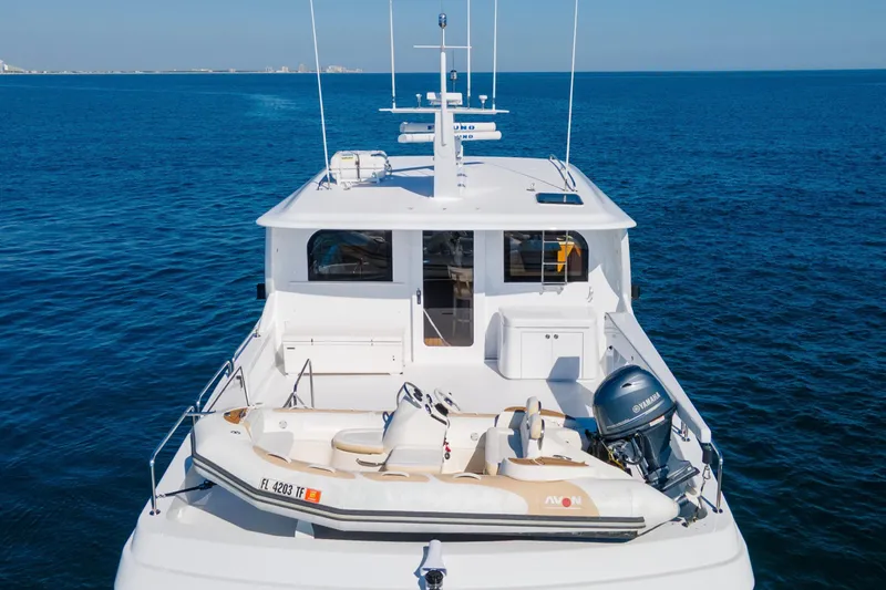 Time-2 Fly Yacht Photos Pics 2006 Hatteras 80 Motor Yacht Sky Lounge on open sea, featuring a tender boat.