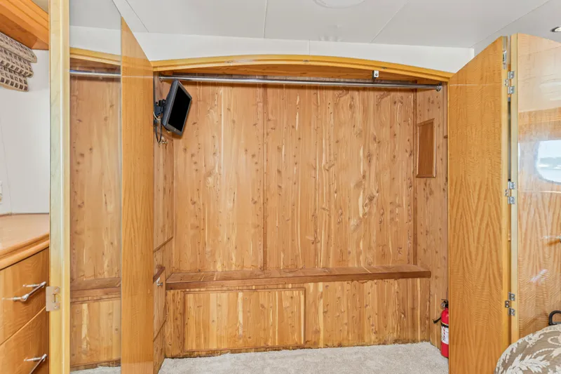 Time-2 Fly Yacht Photos Pics Wood-paneled interior of 2006 Hatteras 80 Motor Yacht Sky Lounge with TV and storage.