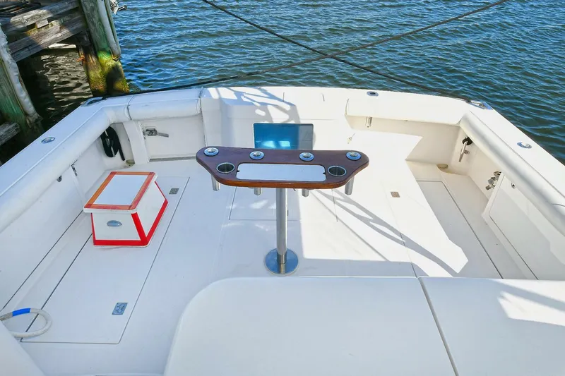 Trios Yacht Photos Pics 2007 Cabo 40 Express boat deck with fishing rod holders, near wooden dock.