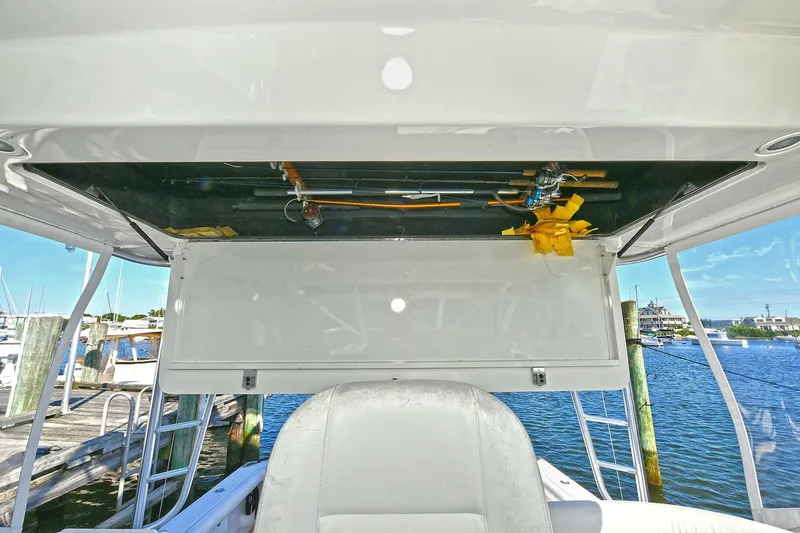 Trios Yacht Photos Pics 2007 Cabo 40 Express with Tower, fishing rods stored overhead, docked at marina.