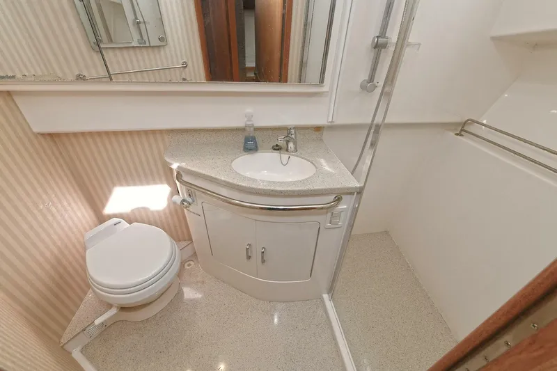 Trios Yacht Photos Pics 2007 Cabo 40 Express bathroom with shower, sink, and toilet in compact design.