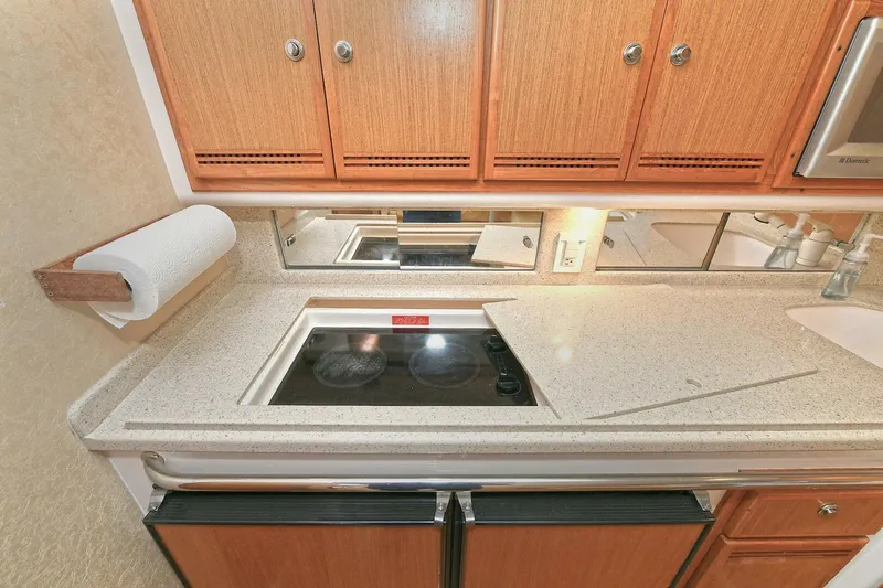 Trios Yacht Photos Pics 2007 Cabo 40 Express kitchen with stove, wooden cabinets, and countertop.