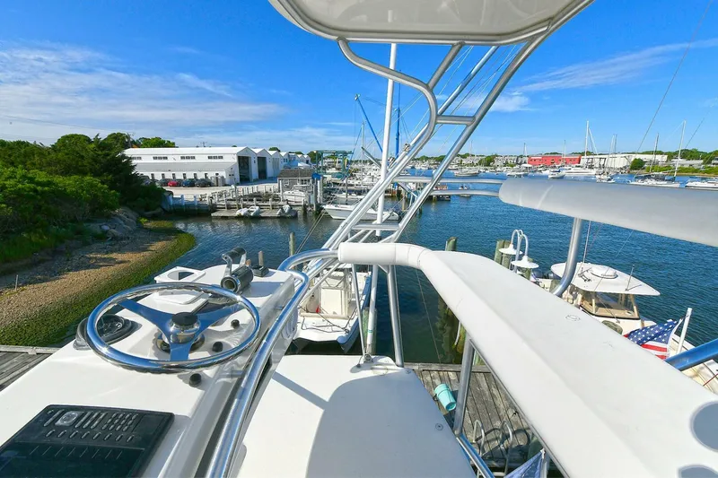 Trios Yacht Photos Pics 2007 Cabo 40 Express with Tower overlooking marina, clear blue sky, and docked boats.