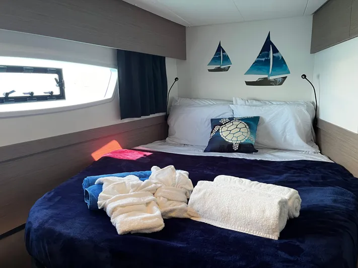 Family Therapy Yacht Photos Pics Luxurious cabin interior of 2023 Fountaine Pajot Elba 45 catamaran with cozy bedding.
