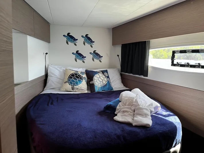 Family Therapy Yacht Photos Pics Cozy bedroom in 2023 Fountaine Pajot Elba 45 yacht with turtle decor and plush bedding.