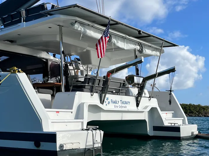 Family Therapy Yacht Photos Pics 2023 Fountaine Pajot Elba 45 catamaran with American flag, docked in serene waters.