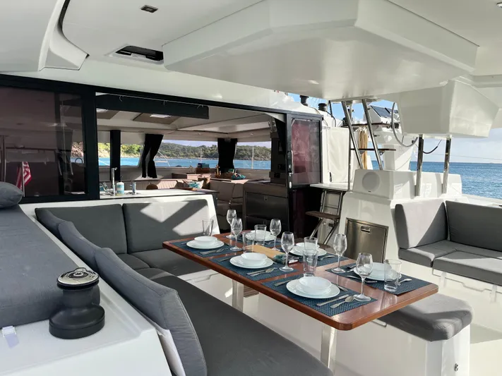 Family Therapy Yacht Photos Pics Luxurious 2023 Fountaine Pajot Elba 45 catamaran with elegant outdoor dining setup.