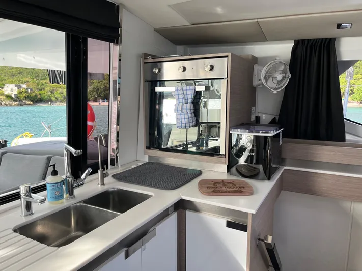 Family Therapy Yacht Photos Pics Modern kitchen interior of 2023 Fountaine Pajot Elba 45 catamaran with ocean view.