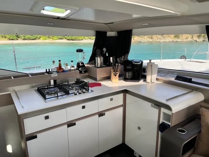 Family Therapy Yacht Photos Pics Modern kitchen interior of 2023 Fountaine Pajot Elba 45 yacht with ocean view.