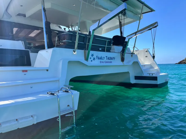 Family Therapy Yacht Photos Pics 2023 Fountaine Pajot Elba 45 catamaran in clear turquoise water, rear view.