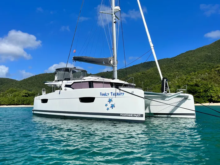 Family Therapy Yacht Photos Pics 2023 Fountaine Pajot Elba 45 catamaran anchored in clear blue waters.
