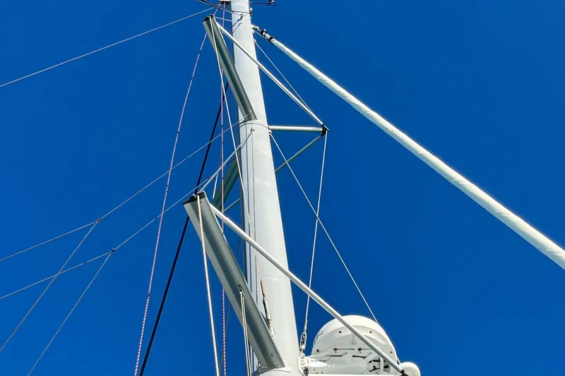 Family Therapy Yacht Photos Pics Mast of 2023 Fountaine Pajot Elba 45 catamaran against clear blue sky.