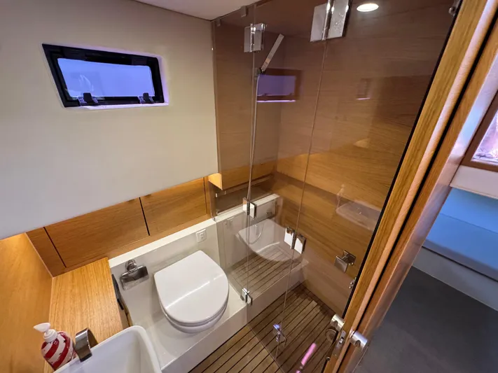  Yacht Photos Pics Modern bathroom interior on 2021 De Antonio Yachts D42, featuring glass shower and wooden accents.