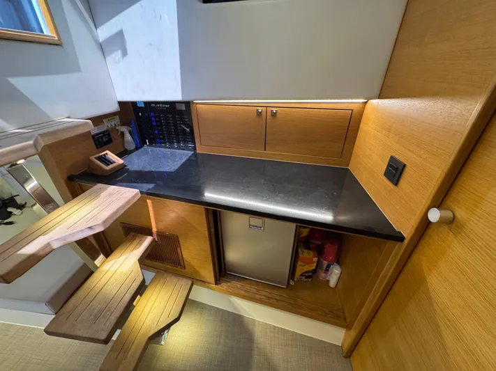  Yacht Photos Pics Interior of 2021 De Antonio Yachts D42, featuring a sleek kitchenette with wooden accents.