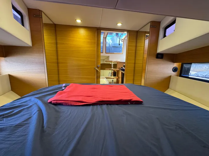  Yacht Photos Pics Interior cabin of 2021 De Antonio Yachts D42 with modern wood finish and cozy bedding.