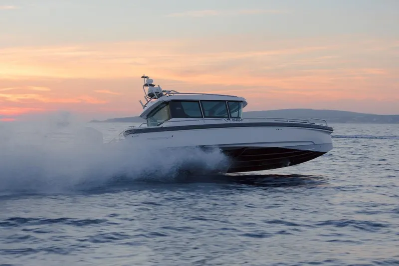  Yacht Photos Pics Axopar 28 CABIN 2022 cruising at sunset on water.