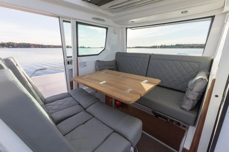  Yacht Photos Pics Interior of 2022 Axopar 28 CABIN with gray seating and wooden table.