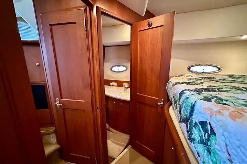  Yacht Photos Pics Interior of 2005 Silverton 43 Motor Yacht with wood cabinetry and cozy bedding.