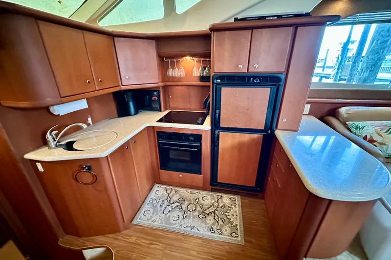  Yacht Photos Pics Luxurious 2005 Silverton 43 Motor Yacht kitchen with wood cabinetry and modern appliances.
