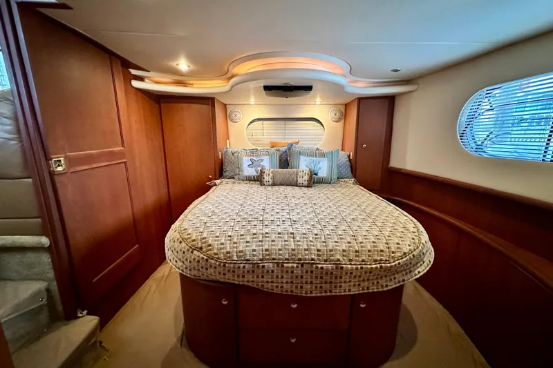  Yacht Photos Pics Luxurious bedroom interior of 2005 Silverton 43 Motor Yacht with elegant wood paneling.