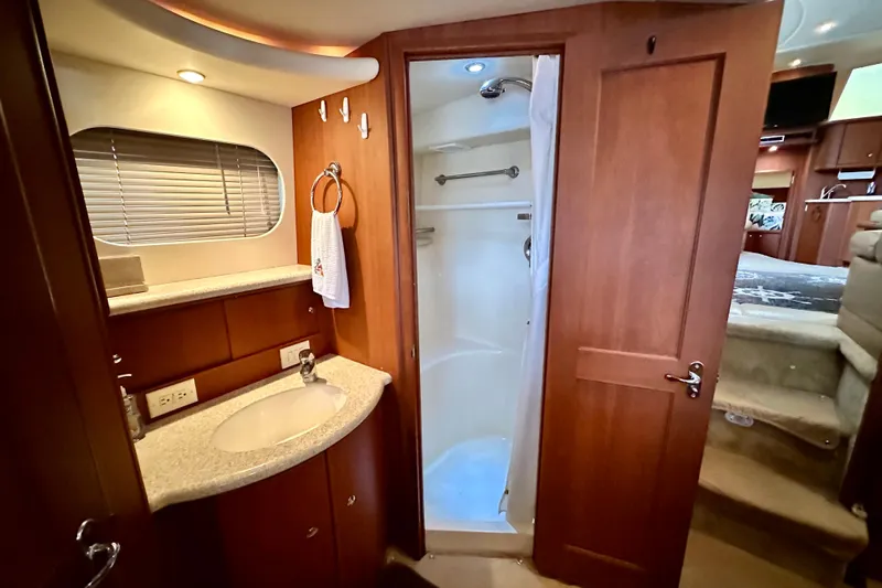  Yacht Photos Pics 2005 Silverton 43 Motor Yacht bathroom with shower, sink, and wooden cabinetry.
