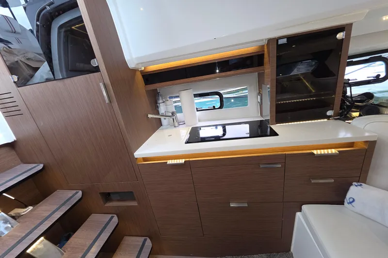  Yacht Photos Pics 2022 Jeanneau Leader 10.5 WA Series 2 interior kitchen with modern wood cabinetry and sleek design.