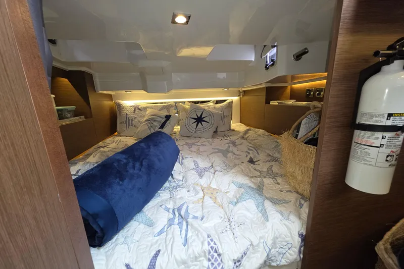  Yacht Photos Pics Cozy cabin interior of 2022 Jeanneau Leader 10.5 WA Series 2 with nautical-themed bedding.