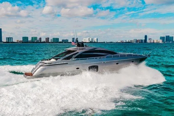 Andiamo Yacht Photos Pics 2015 Pershing 70 yacht cruising on blue ocean with city skyline in background.