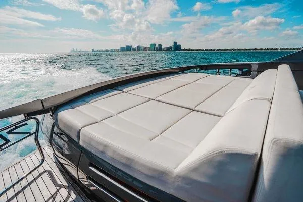 Andiamo Yacht Photos Pics Luxurious 2015 Pershing 70 yacht with sunbed, cruising on open water under a bright sky.