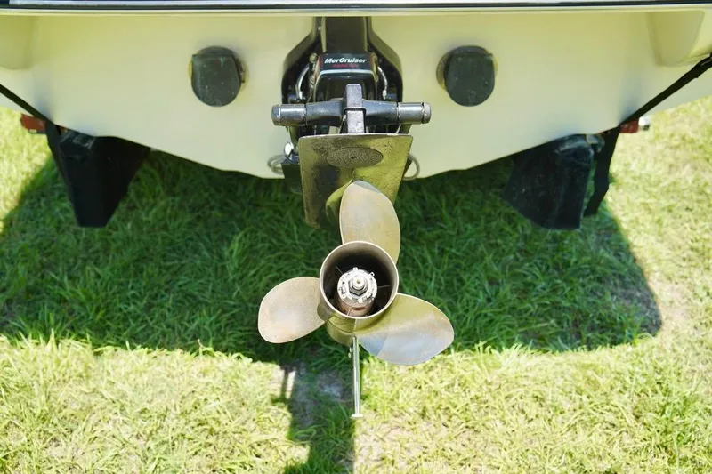  Yacht Photos Pics 2001 Stingray 240 LS boat propeller on grass, rear view.