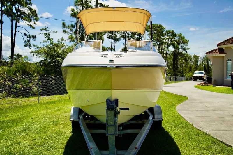  Yacht Photos Pics 2001 Stingray 240 LS boat on trailer, parked on grass, sunny day.