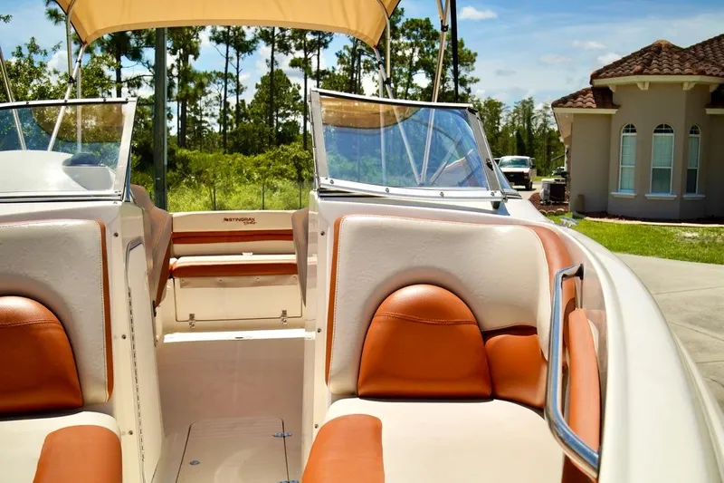  Yacht Photos Pics 2001 Stingray 240 LS boat interior with tan and brown seating, sunny day.