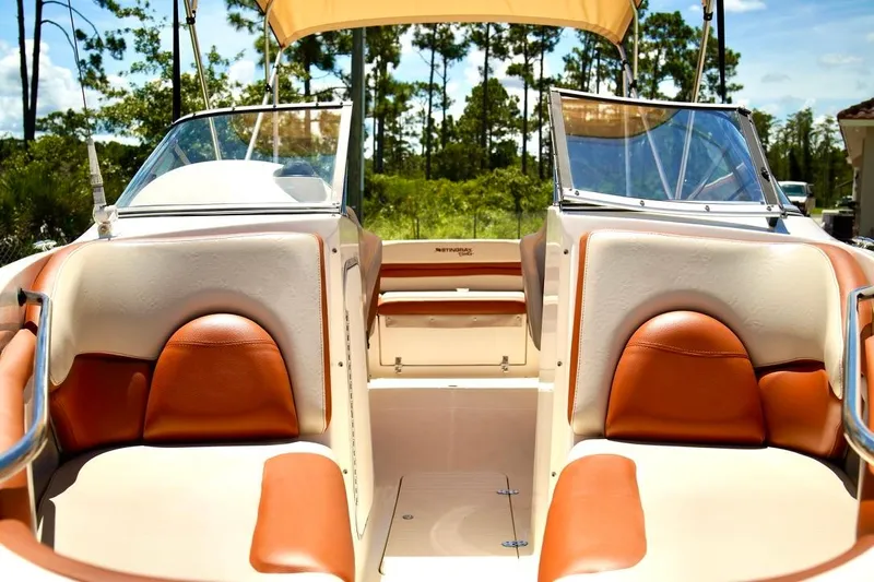 Yacht Photos Pics 2001 Stingray 240 LS boat interior with tan and brown seating, sunny outdoor setting.