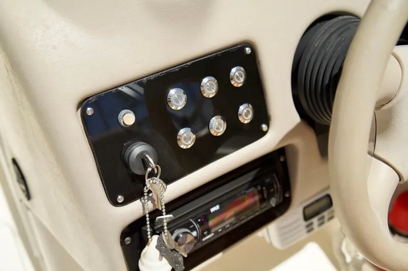  Yacht Photos Pics Dashboard of a 2001 Stingray 240 LS boat with ignition keys and control panel.