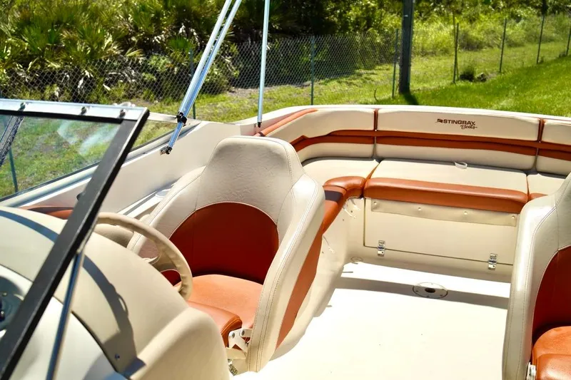  Yacht Photos Pics 2001 Stingray 240 LS boat interior with tan and orange seating, sunny day.
