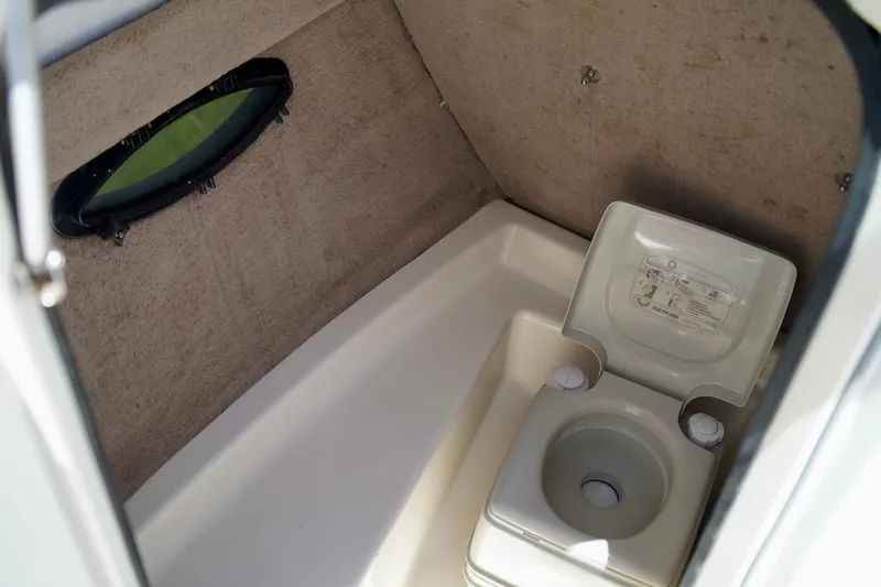  Yacht Photos Pics 2001 Stingray 240 LS boat interior with portable toilet and small window.