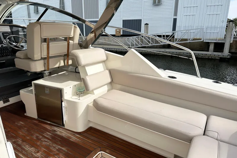 Yolo Or 2 Yacht Photos Pics 2014 Pursuit SC 365i Sport Coupe interior with white seating and wooden flooring.