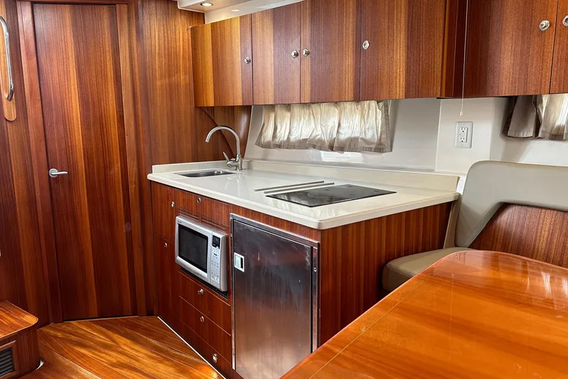Yolo Or 2 Yacht Photos Pics Luxurious 2014 Pursuit SC 365i Sport Coupe interior with wood cabinetry and modern kitchen amenities.