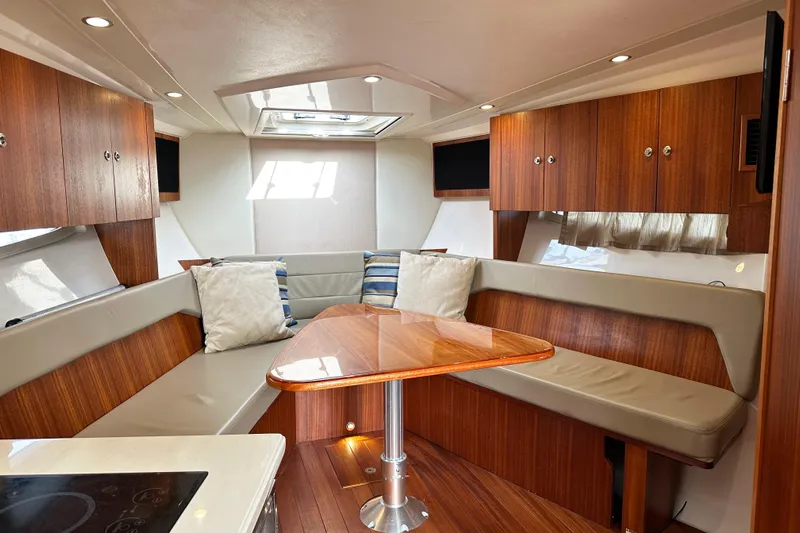 Yolo Or 2 Yacht Photos Pics 2014 Pursuit SC 365i Sport Coupe interior with wood finish and cozy seating area.