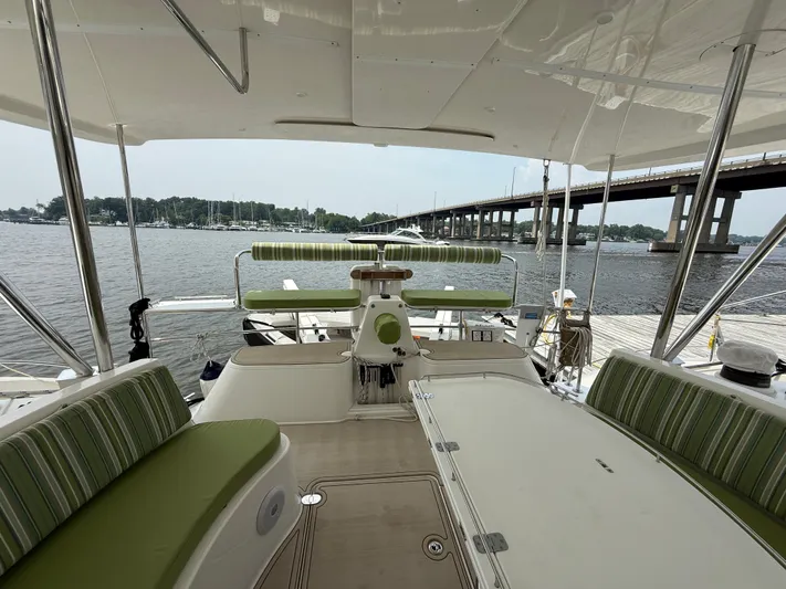 Two Fish Yacht Photos Pics Luxurious Antares 44GS yacht interior with green-striped seating, docked by a scenic waterfront.