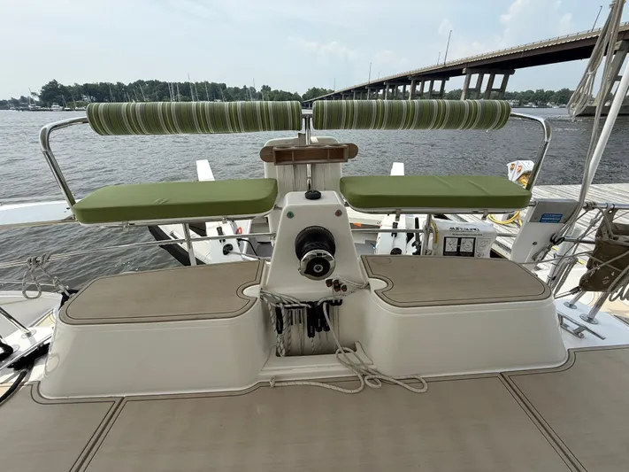 Two Fish Yacht Photos Pics Helm of 2021 Antares 44GS yacht with green seating, docked by a bridge.