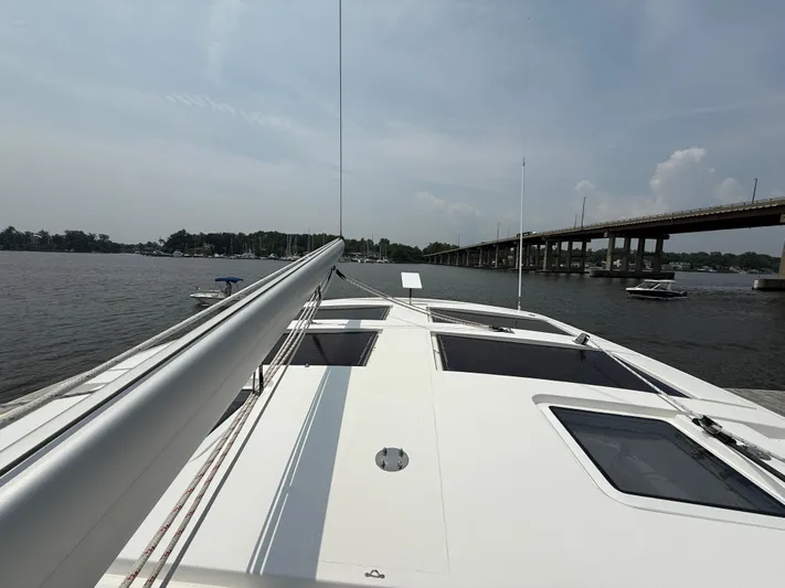 Two Fish Yacht Photos Pics Sailing on Antares 44GS yacht, 2021 model, near a bridge on a calm river.