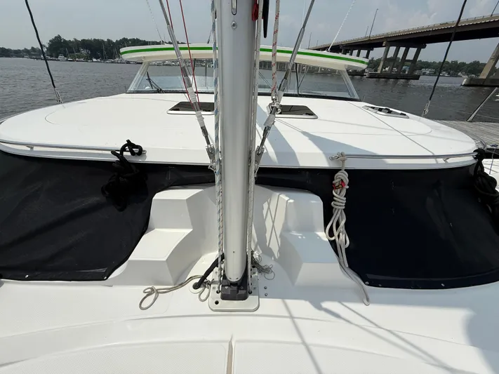 Two Fish Yacht Photos Pics 2021 Antares 44GS catamaran deck with mast, docked near a bridge.
